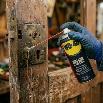 Puszka WD-40 250 ml podczas pracy przy odblokowywaniu zamka drzwiowego